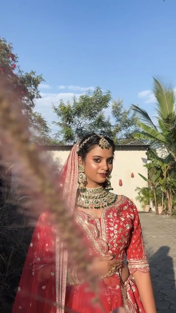 Bride in a red zari lehenga with gold jewellery, from Pratha