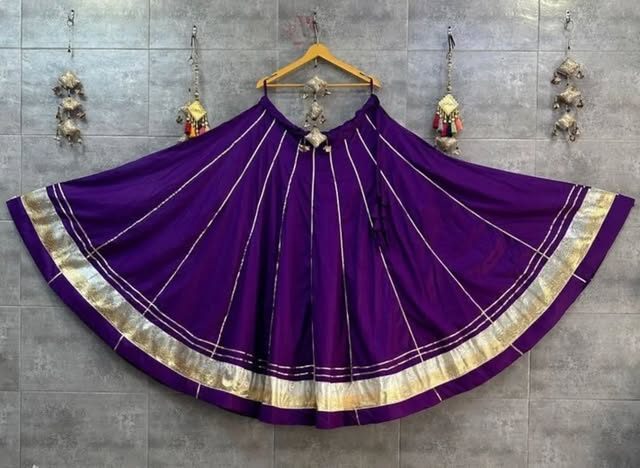 Purple flared chaniya with gold stripes on a hanger